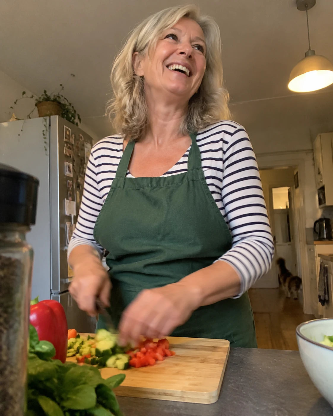 Woman laughing while cooking in her kitchen