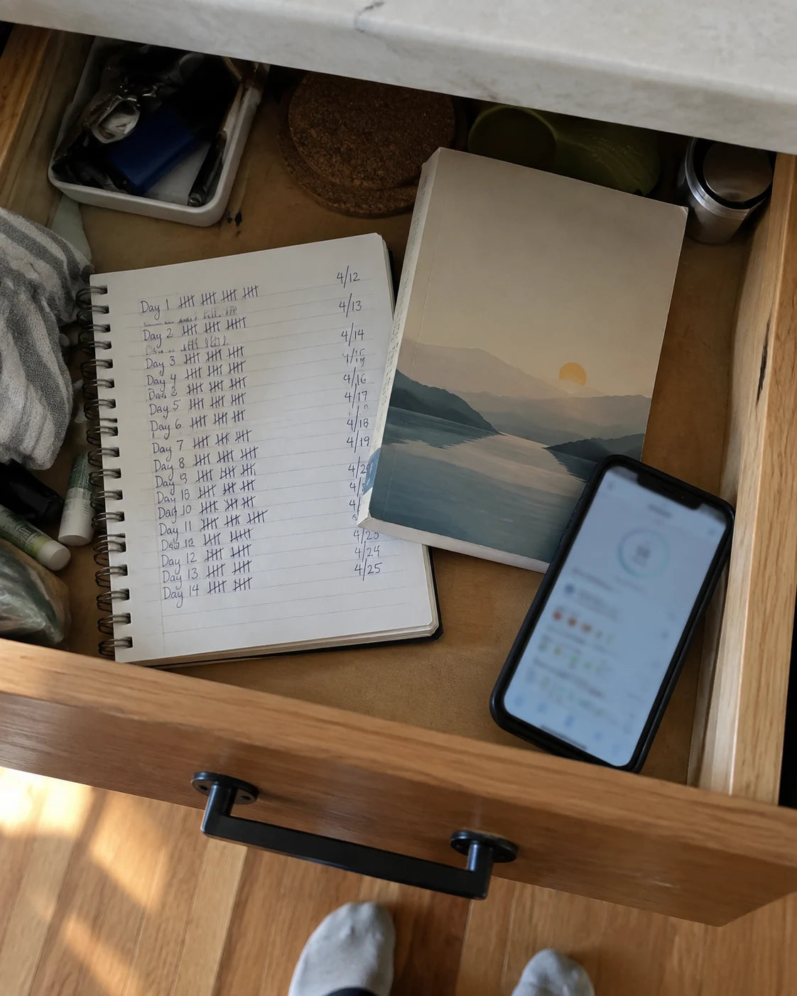 A drawer with a notebook, a book, and a phone showing past attempts to cut back