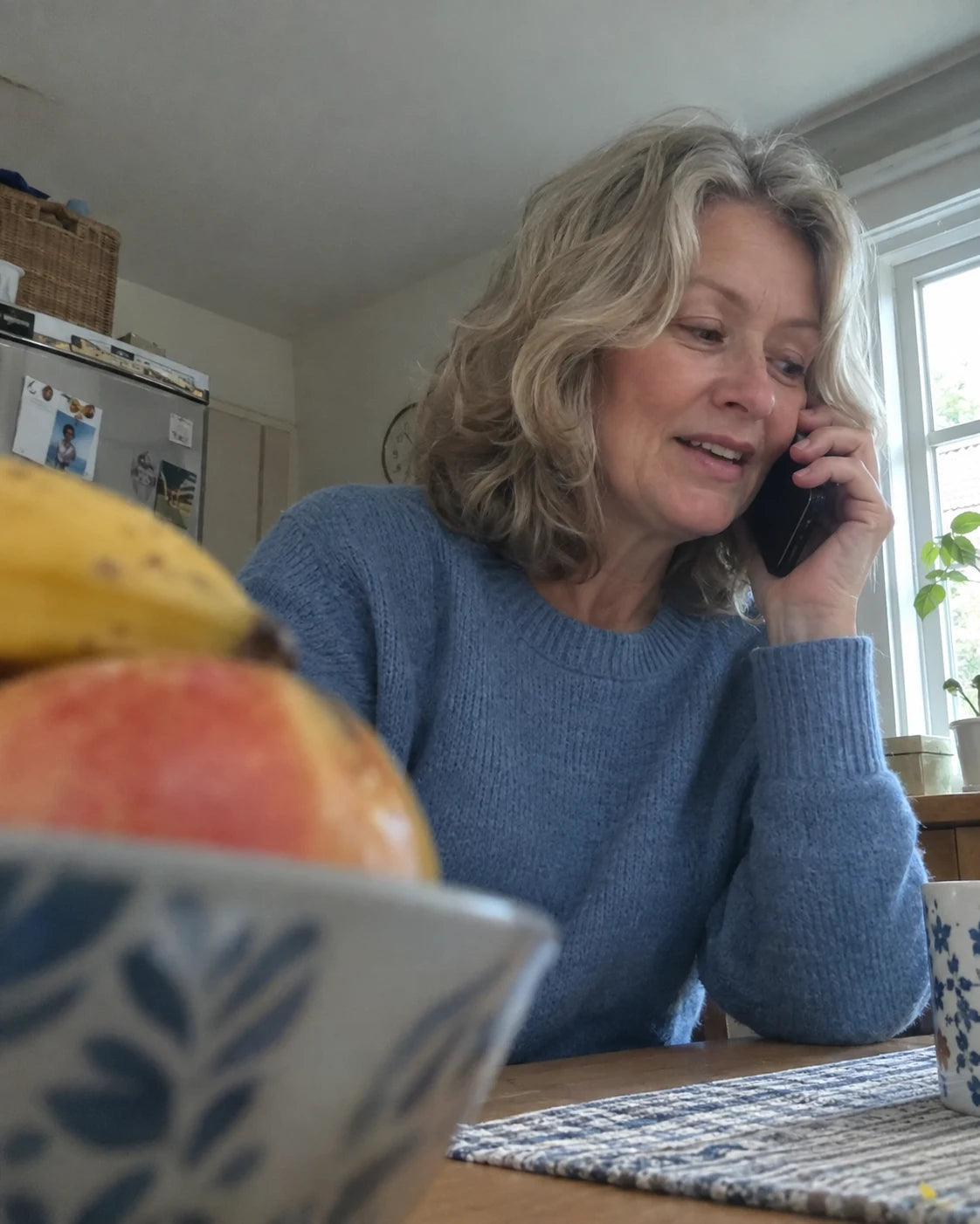 Woman on the phone at her kitchen table