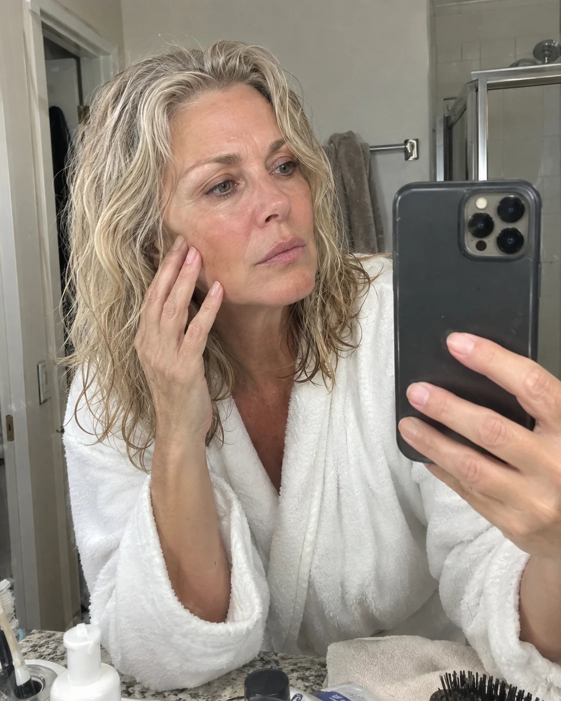 Woman examining her face in the bathroom mirror