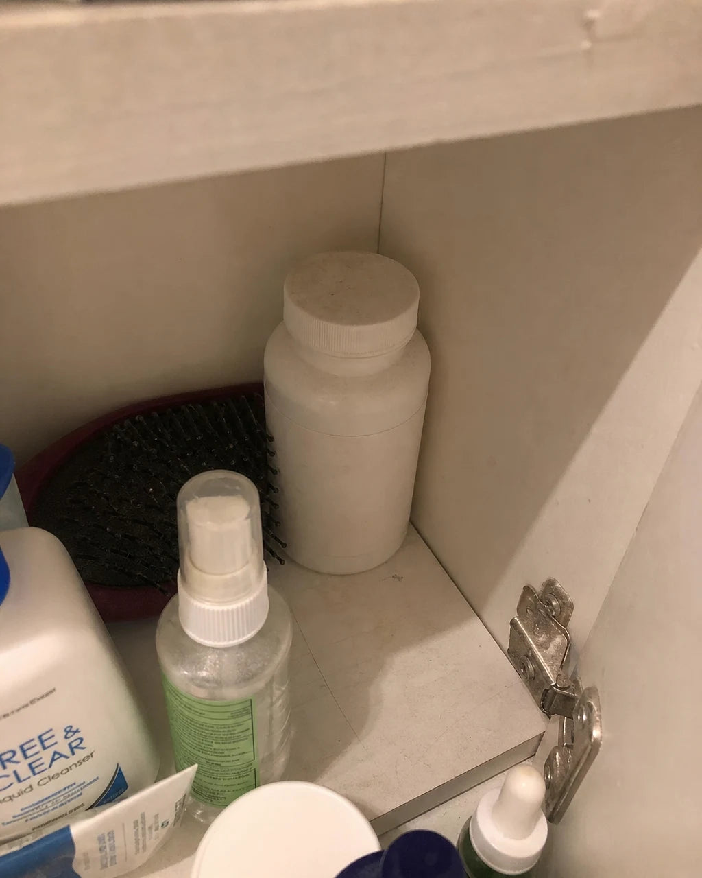 An old, unused melatonin bottle pushed to the back of a shelf